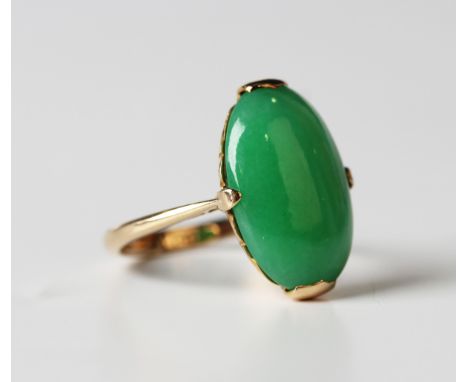 A gold ring, claw set with an oval cabochon jade, detailed '18ct', weight 4.2g, ring size approx L, with a case.Buyer’s Premi