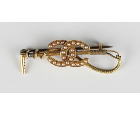 An Edwardian gold and seed pearl brooch, designed as two entwined horseshoes and a riding crop, unmarked, weight 6.1g, width 