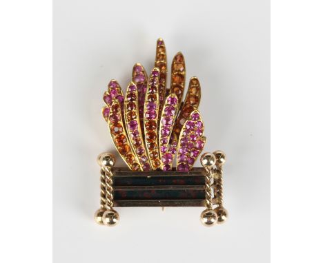 A gold, ruby and citrine brooch, designed as a fire grate, mounted with a bloodstone set panel to the centre of the grate, th