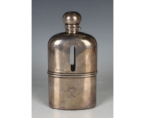 A late Victorian silver mounted clear glass hip flask, the detachable cup with engraved crest, fitted with a screw hinged lid