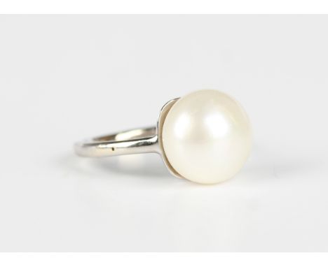 A white gold ring, mounted with a cultured pearl, detailed '750', weight 4.9g, ring size approx M.Buyer’s Premium 29.4% (incl