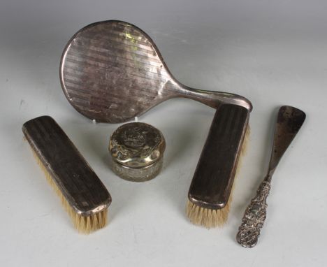 A George V silver three-piece dressing table set with engine turned decoration, comprising hand mirror and two clothes brushe