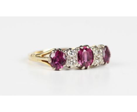 A gold, ruby and diamond ring, mounted with three oval cut rubies alternating with two pairs of cushion cut diamonds, detaile