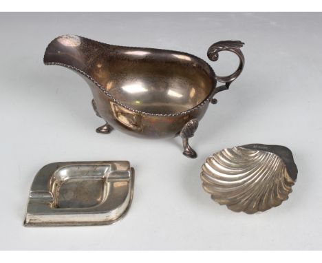 A George VI silver sauceboat with foliate capped flying scroll handle, raised on scallop shell shouldered scroll legs termina