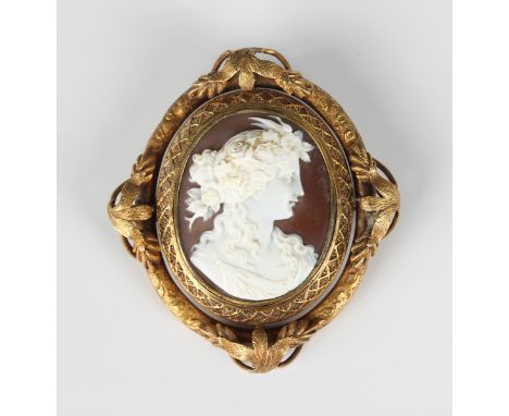 A Victorian gold mounted oval shell cameo brooch, circa 1850, carved as a portrait of a lady, the decorated mount spaced with