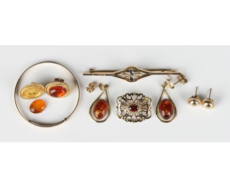 A 9ct gold brooch in a pierced design, mounted with an oval cut garnet, Birmingham 1994, width 2.2cm, a gold, seed pearl and 