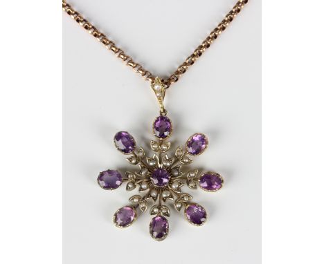 A gold, amethyst and seed pearl pendant in a floral design, mounted with a circular cut amethyst within a surround of eight o