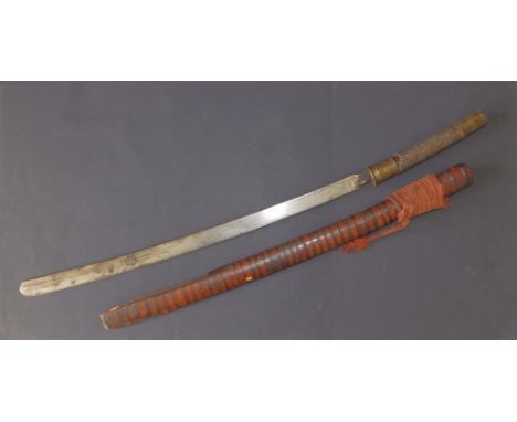 A 19thC Indonesian sword in wooden scabbard, having slightly curved 22.5" blade, the brass mounted hilt with an incomplete sh