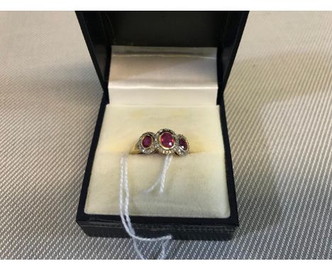 9ct gold ladies ring set with 3 ruby stones set with diamond surrounds. Weighs 2.32 grams 