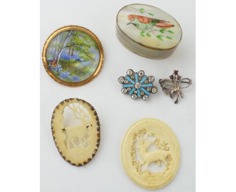 A collection of jewellery to include carved antler brooches, a Victorian enamel and paste brooch, a brass mother of pearl tri