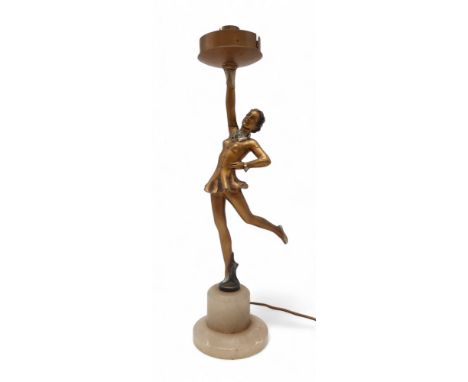 AN ART DECO SPELTER LADY LAMP modelled wearing a short dress with one arm raised, the other on her hip, mounted on alabaster 
