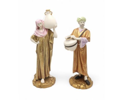 A PAIR OF LARGE ROYAL WORCESTER FIGURES modelled as water carriers, after James Hadley, both with gilt cloaks, she with a pin