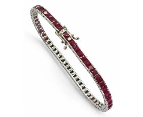 RUBY LINE BRACELET set with fifty seven square cut rubies in tension settings, the mount in 18ct white gold, with full UK hal