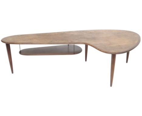 A 20TH CENTURY DANISH AFROMOSIA TEAK "BOOMERANG" COFFEE TABLE  with stylistically shaped top over lower tiered shelf on shape