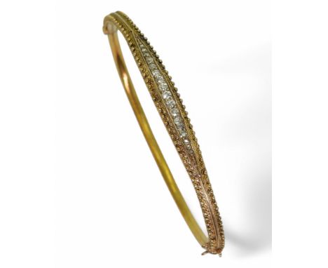 AN ETRUSCAN REVIVAL BANGLE made in 15ct gold with wirework and granulation detail the centre set with an estimated approx 0.2