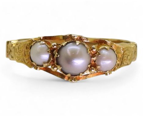 AN ANTIQUE PEARL RING the bright yellow metal scrolled mount with engraved detail to the shoulders. Set with three half pearl