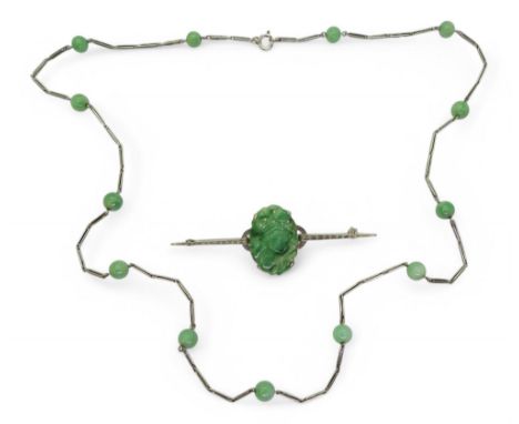 CHINESE GREEN HARDSTONE JEWELS A 9ct white gold brooch set with a fruit carved and pierced oval hardstone. Length 6.5cm, weig