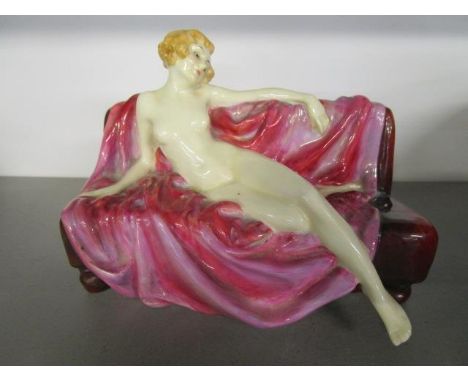 Leslie Harradine for Royal Doulton - Siesta HN1305, a nude figurine of a woman reclining on a red sofa, issued circa 1928, 6 