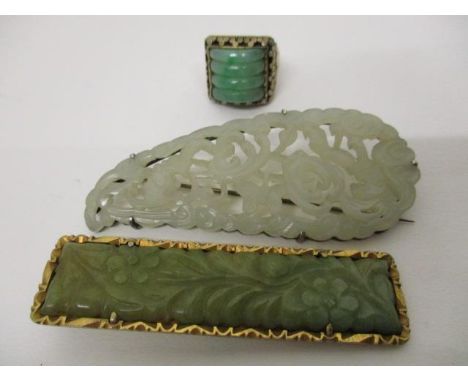 A Chinese silver gilt ring set with a curved, ribbed jade panel and a carved and pierced jade brooch with leaf decoration, in