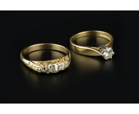 TWO DIAMOND SET RINGS, comprising a five stone ring, the graduated old-cut diamonds set above a scroll decorated gallery, yel