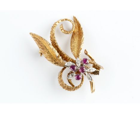 A RUBY AND DIAMOND SET BROOCH, designed as a textured foliate spray, highlighted with circular mixed-cut rubies and single-cu