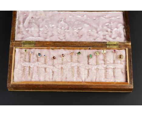 A COLLECTION OF STICK PINS, variously gem set and stone set, to include an emerald single stone stick pin,  a green tourmalin