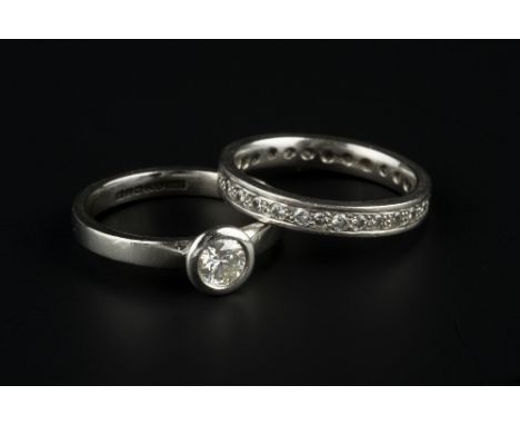 A DIAMOND SINGLE STONE RING, the round brilliant-cut diamond in collet setting, to a uniform band, palladium mounted, accompa