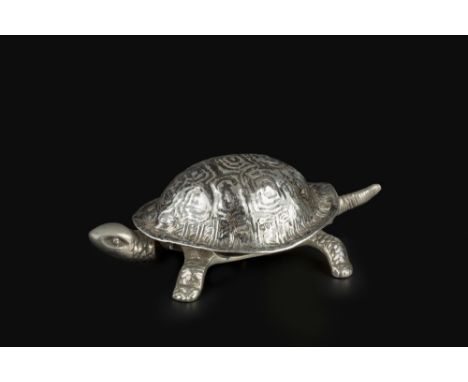 A SILVER MOUNTED NOVELTY TABLE BELL, in the form of a tortoise, the clock work mechanism activated by pressing either the hea