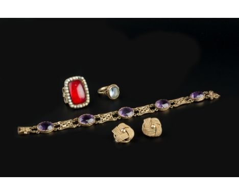 AN AMETHYST PANEL BRACELET, the oval mixed-cut amethysts spaced by pierced lozenge-shaped panels, 9ct gold mounted, together 