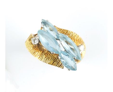 AN AQUAMARINE AND DIAMOND DRESS RING, of crossover design, obliquely claw set with a cluster of graduated navette-shaped aqua