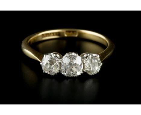 A DIAMOND THREE STONE RING, the graduated cushion-shaped old-cut diamonds in claw setting, two colour precious metal mounted,