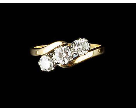 A DIAMOND THREE STONE RING, of crossover design, the graduated round brilliant-cut diamonds in claw setting, 18ct two colour 