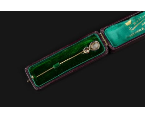 AN EARLY VICTORIAN ENAMEL AND HAIRWORK MEMORIAL STICK PIN, modelled as a scrolled serpent, its body heightened with blue enam