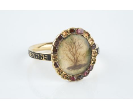 AN ENAMEL AND STONE SET MEMORIAL RING, centred with an oval hairwork panel depicting a tree, bordered by a row of cushion-sha