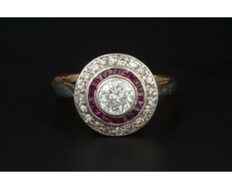 A DIAMOND AND RUBY PANEL RING, the principal round brilliant-cut diamond collet set to a circular millegrained panel, with st
