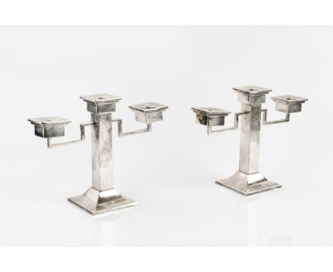 A PAIR OF 1930'S JAPANESE SILVER TWIN BRANCH THREE LIGHT CANDLESTICKS, with square section columns and drip pans, and angular