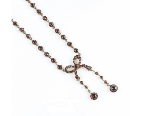 A BOHEMIAN GARNET PENDANT NECKLACE, designed as a ribbon bow of circular rose-cut garnets with graduated pendant drops, suspe