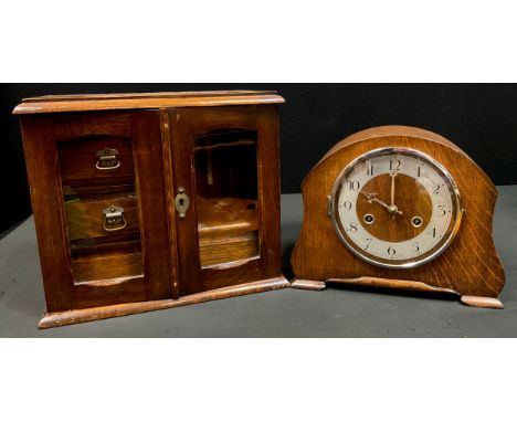 A 20th century oak smokers cabinet, lift up lid, two glazed doors, fitted interior with three drawers, pipe rack and mixing b