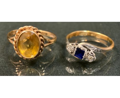 A diamond and sapphire three stone ring, central square deep blue sapphire, approx 0.20ct, dividing a pair of round brilliant