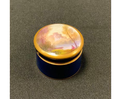 A Royal Worcester cylindrical box, the cover painted by Rushton, signed with castle, lake and figure, cobalt blue ground, out