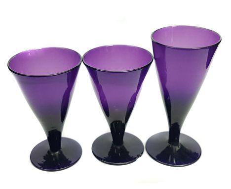 Three amethyst coloured  glasses, conical on circular foot, 10cm max (3)