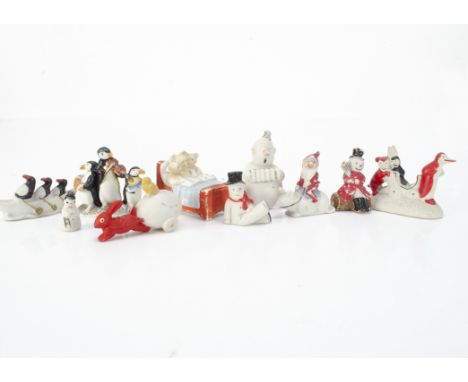 Ten bisque amusing cake decorations,  a rabbit pulling an egg with chick on top --2 ½in. (6cm.) long, three penguins rowing a