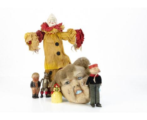 A Caley's Christmas cracker composition headed clown,  with yellow and red crepe costume and original tag --18 ½in. (47cm.) h