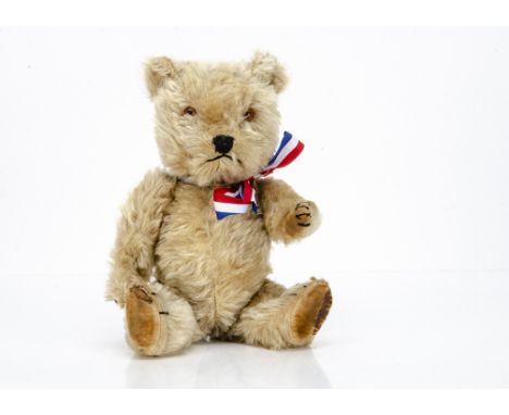 A post-war Chiltern Hugmee teddy bear,  with blonde mohair, orange and black plastic eyes, black stitched nose, mouth and cla