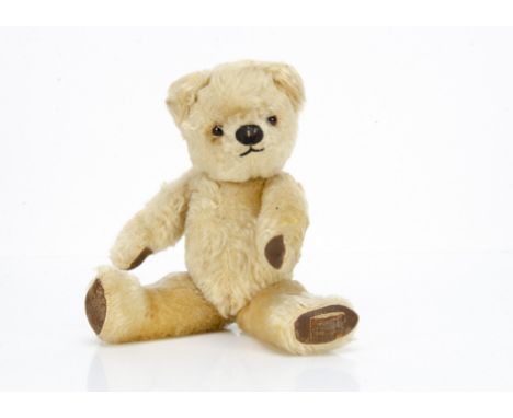 A post-war Chad Valley teddy bear, with blonde mohair, orange and black glass eyes, muzzle with black stitched nose and mouth