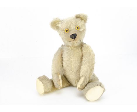 A Chad Valley moon-eyed teddy bear 1920s,  with blonde mohair, clear and black glass eyes with yellow backs, pronounced clipp