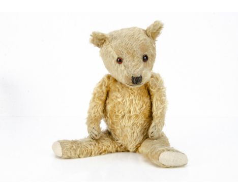 A 1930s Chiltern-type teddy bear, with golden mohair, orange and black odd sized glass eyes, pronounced muzzle, black stitche