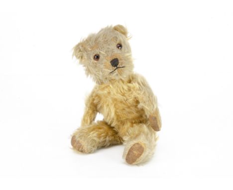 A post-war Chiltern Hugmee teddy bear,  with golden mohair, orange and black glass eyes, muzzle with black stitched nose and 