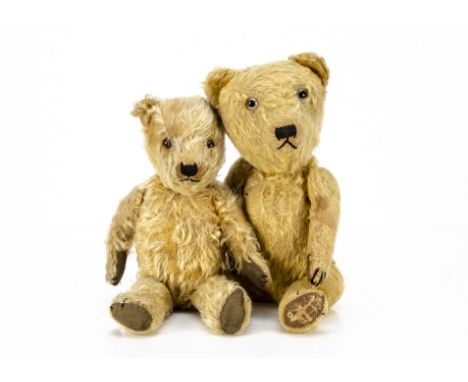 Two post-war British teddy bears, both with golden mohair, swivel heads and jointed limbs, the larger with clear and black gl