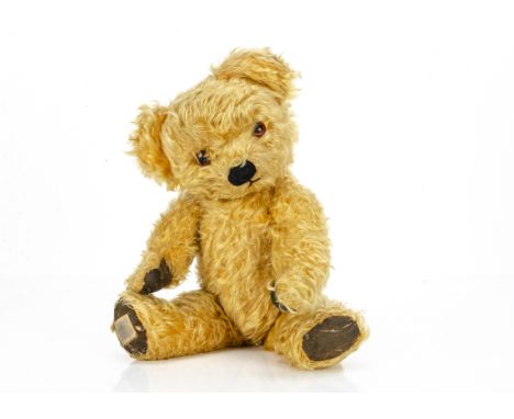 A post-war Chad Valley teddy bear,  with golden mohair, orange and black glass eyes, black stitched nose and mouth, swivel he